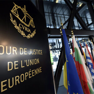 Schild des Europäischen Gerichtshofs, im Hintergrund Flaggen
