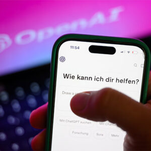 Dieses Foto zeigt ein Smartphone. Auf dem Bildschirm ist die Benutzeroberfläche einer KI zu sehen mit dem Schriftzug: Wie kann ich dir helfen?